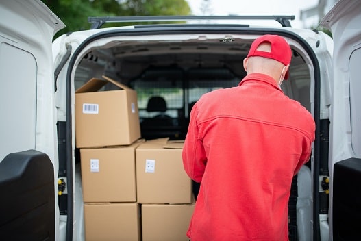 Un livreur charge des caisses dans sa camionnette