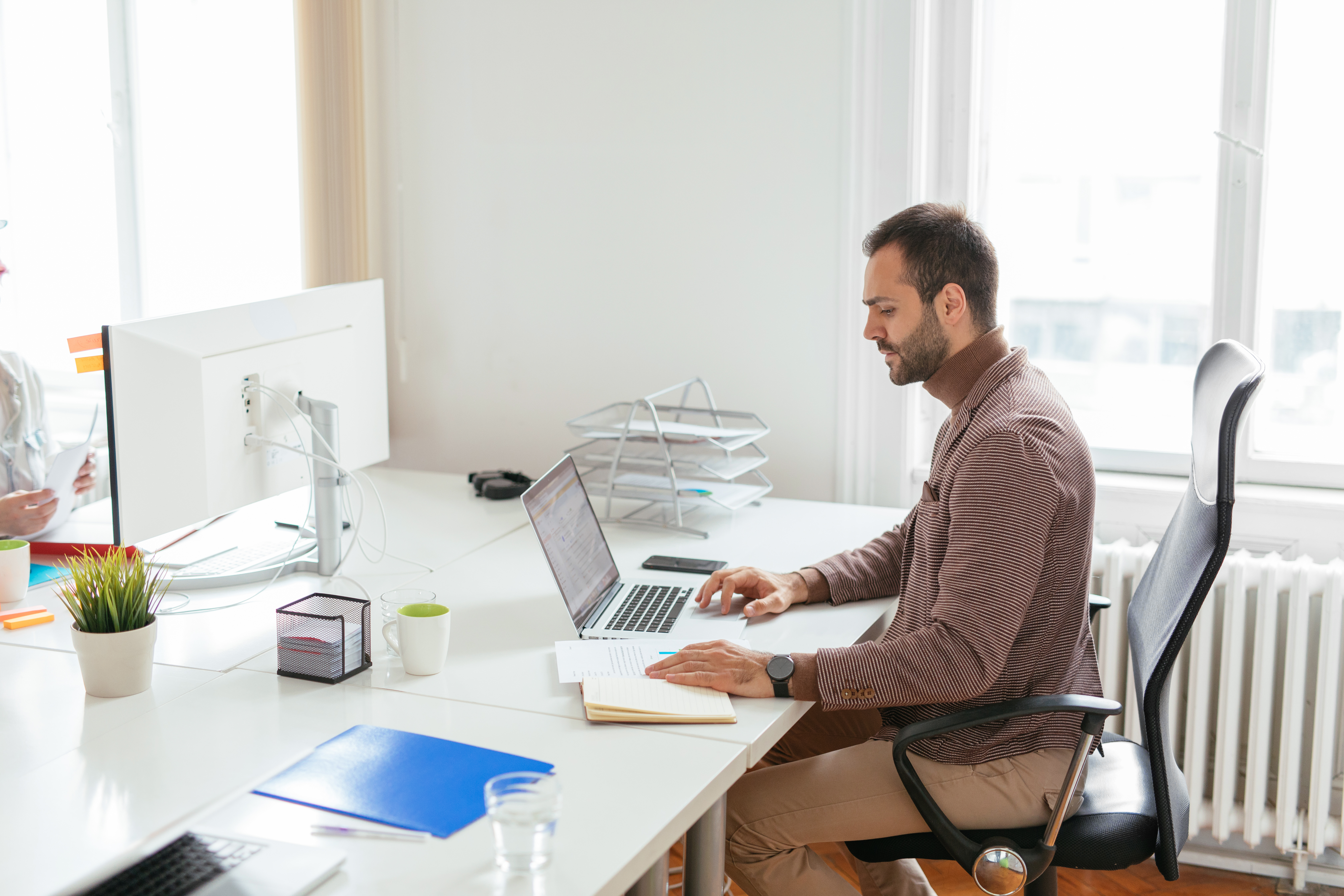 employee working on laptop and notepad