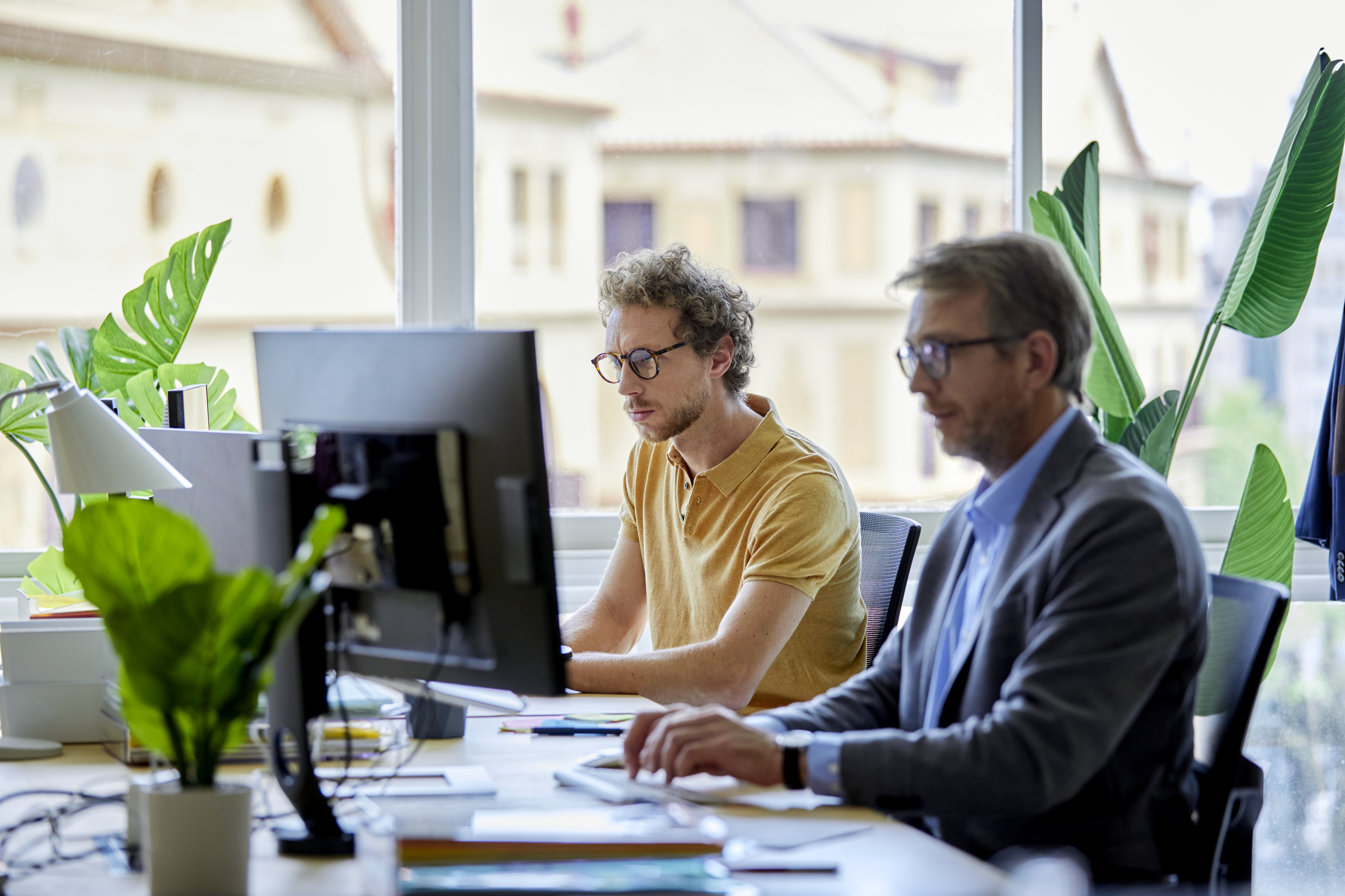 Two office employees working on computers