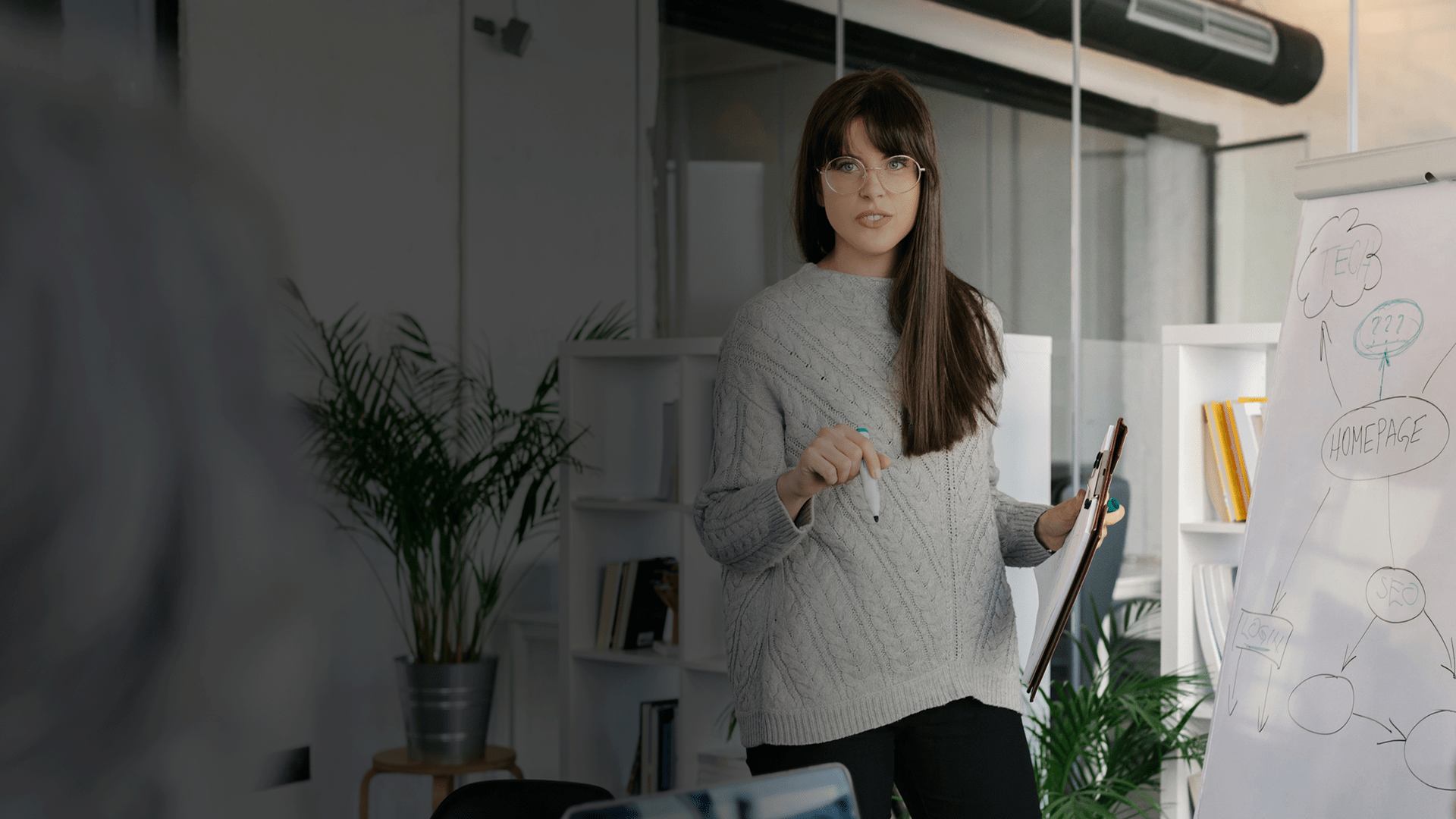 Une femme en train de faire une présentation avec un tableau blanc