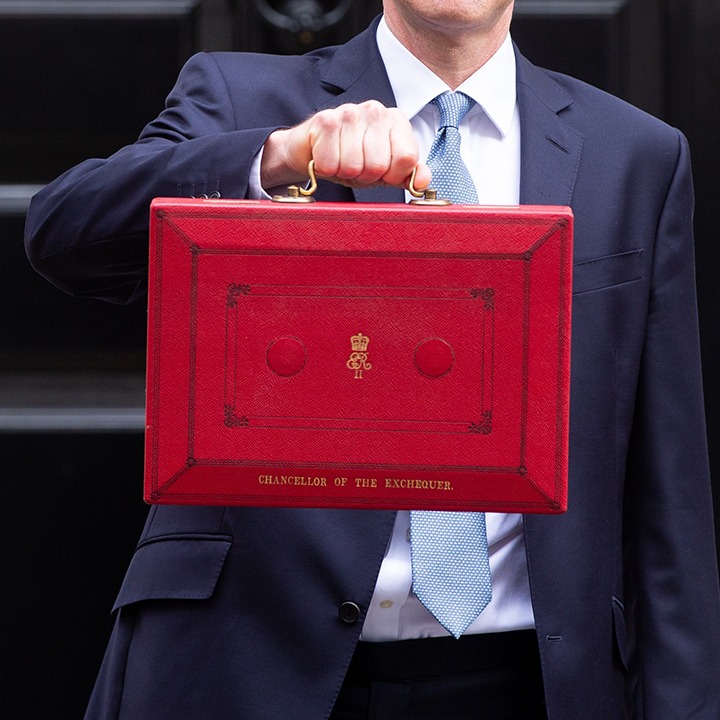 Man in a suit holding a red briefcase illustrating the UK spring budget announcement by the Chancellor of the Exchequer.